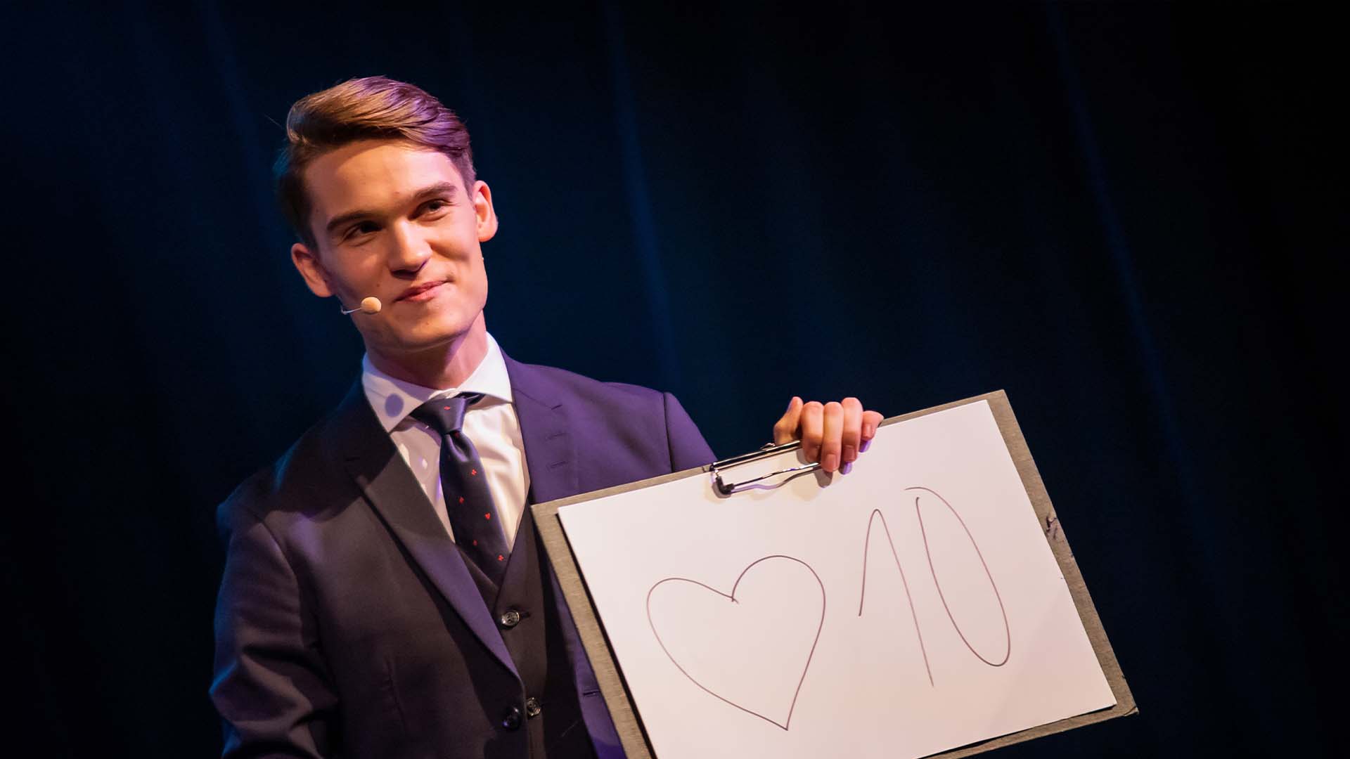 Vincent Frommer präsentiert die Herz 10 auf einem A3-Block bei der Show „Magie der Intuition“