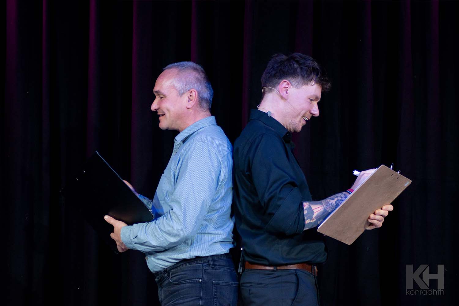 Thomas Majka und ein Mann stehen Rücken an Rücken und zeichnen etwas auf Blöcke