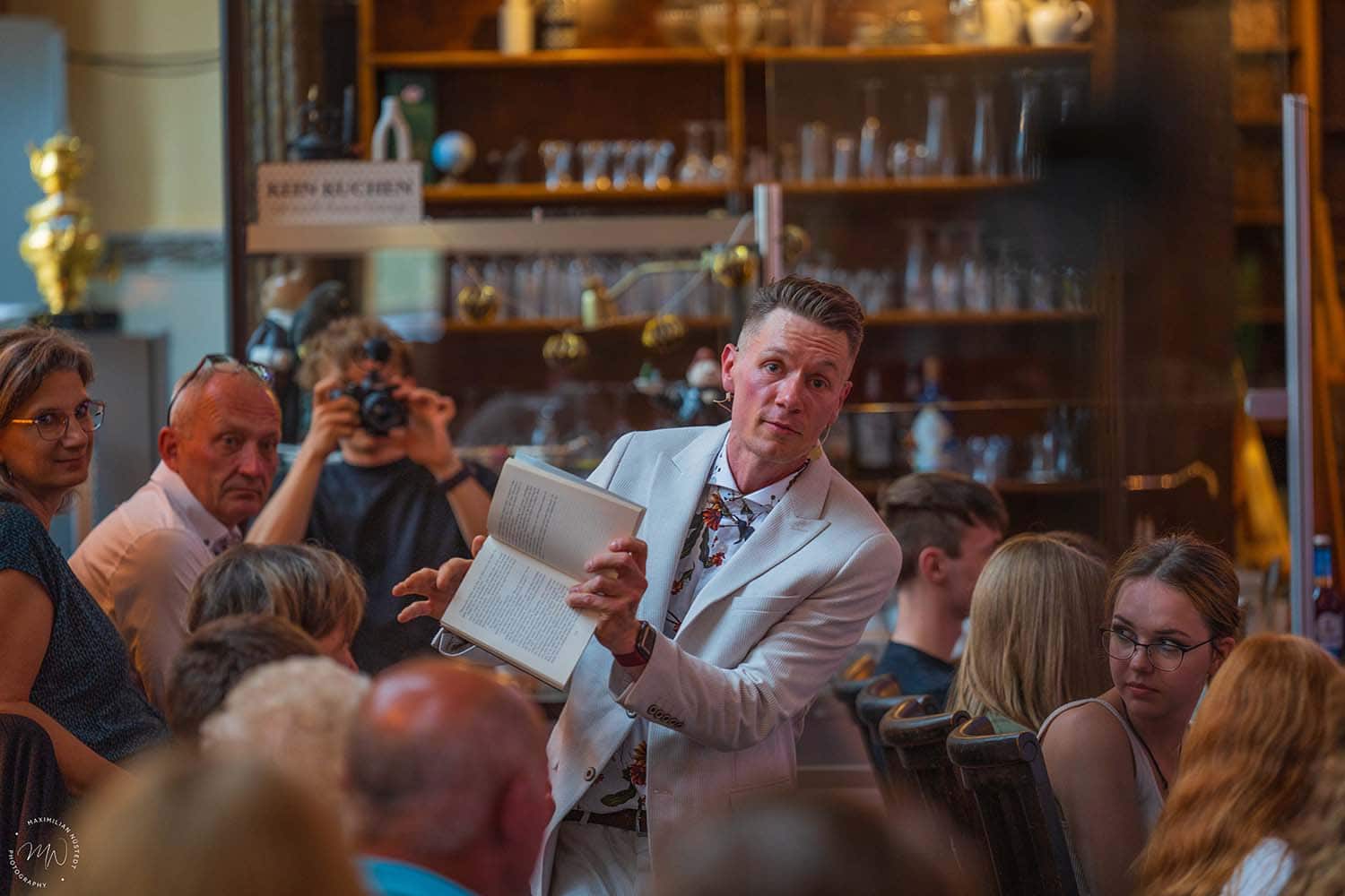 Thomas hält ein Buch, während das Publikum ein Wort auswählt.