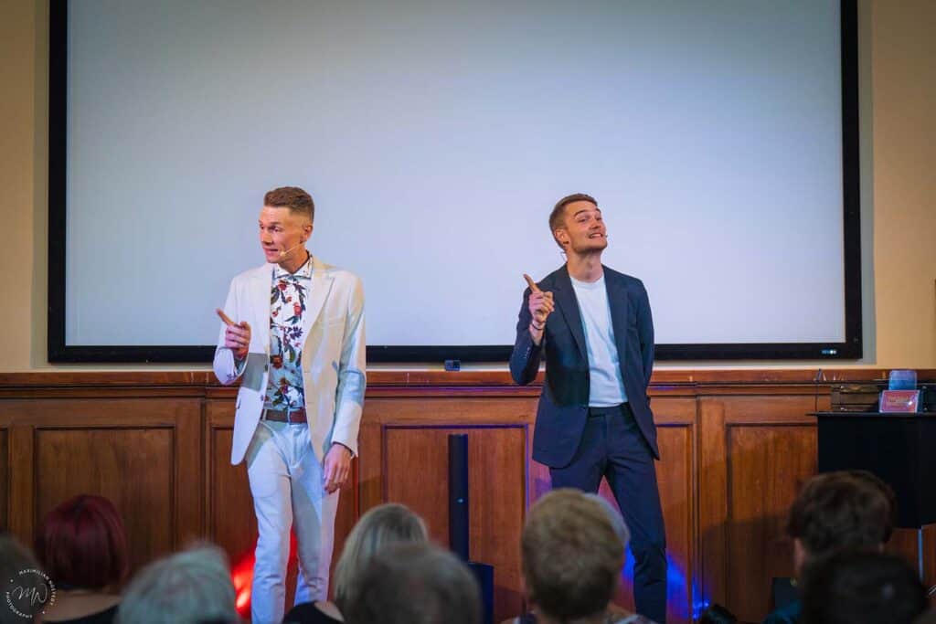 Thomas Majka und Vincent Frommer stehen auf der Bühne und sprechen mit dem Publikum.