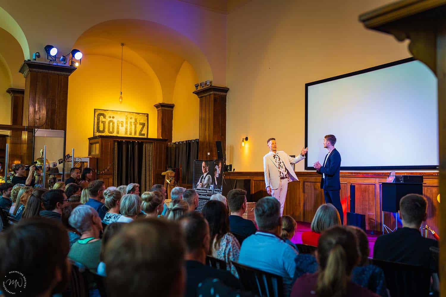 Thomas und Vincent stehen auf der Bühne, mit Blick aus dem Zuschauerraum.