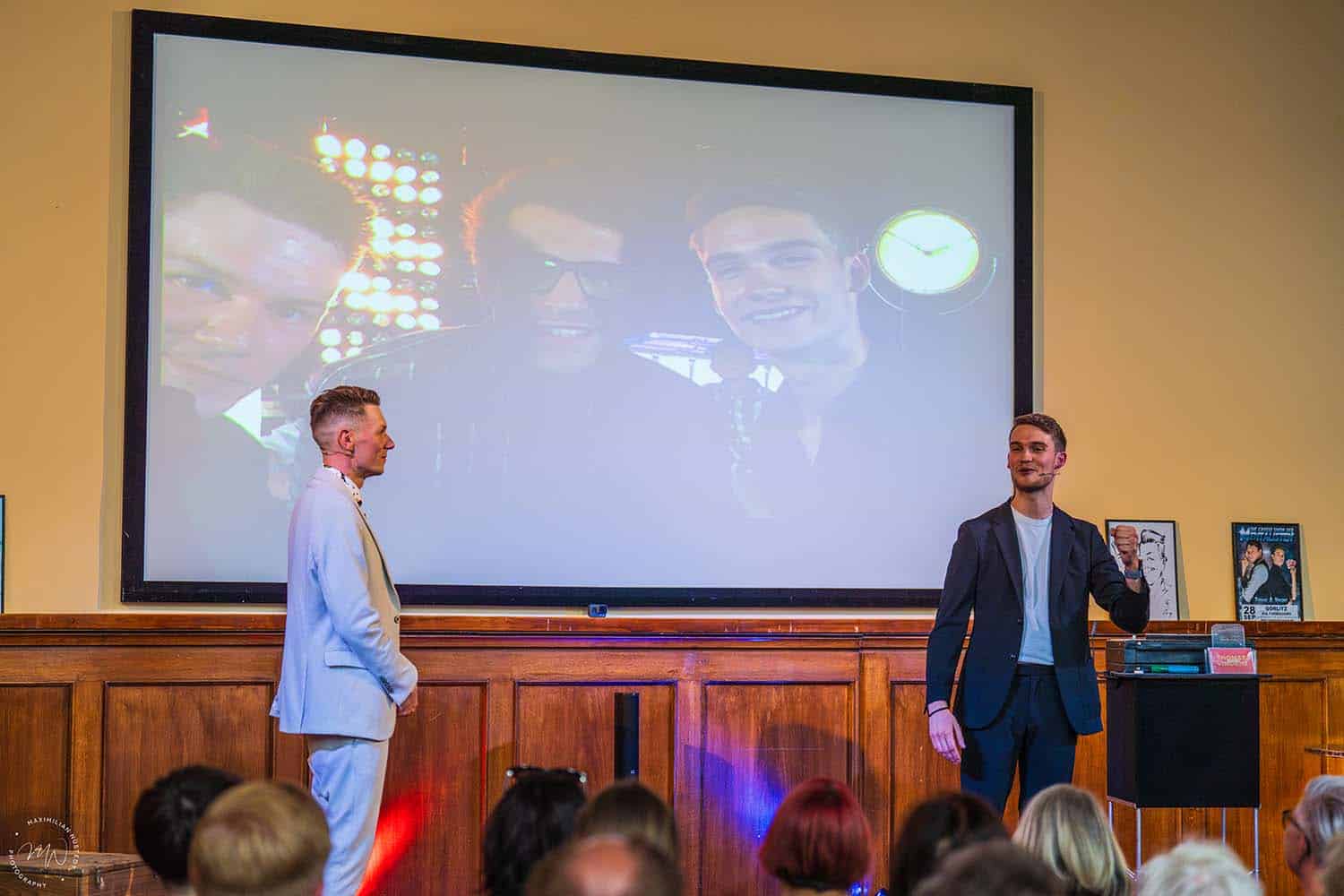 Thomas und Vincent erzählen auf der Bühne vom Supertalent-Auftritt mit Daniel Hartwig im Hintergrund.