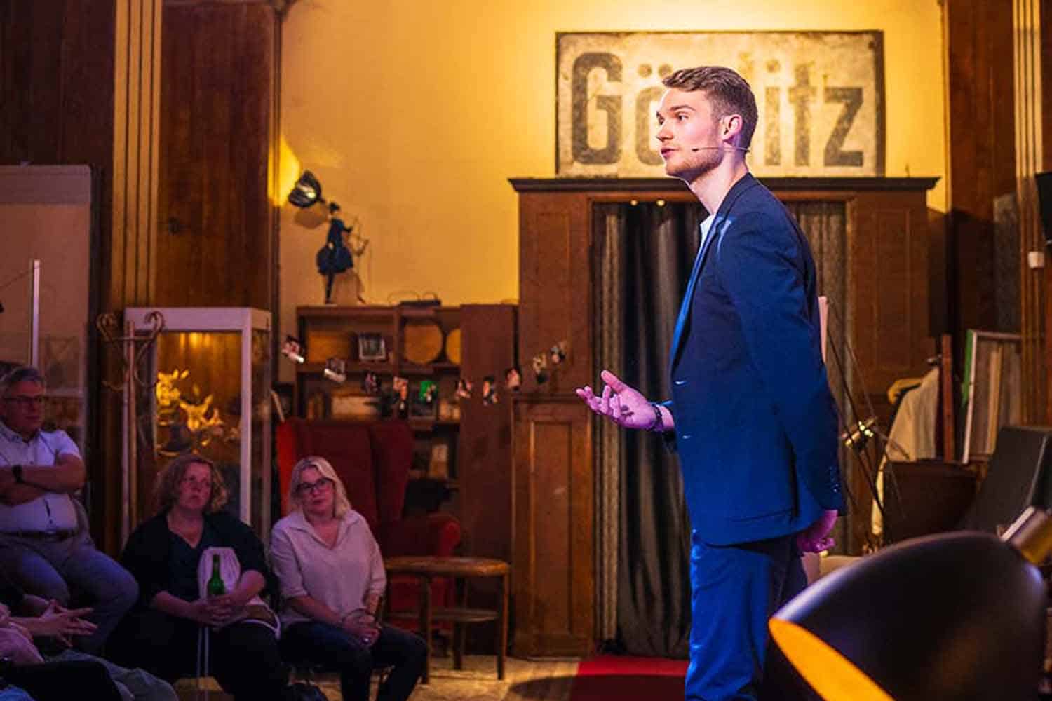 Vincent erklärt einen weiteren Trick dem Publikum.