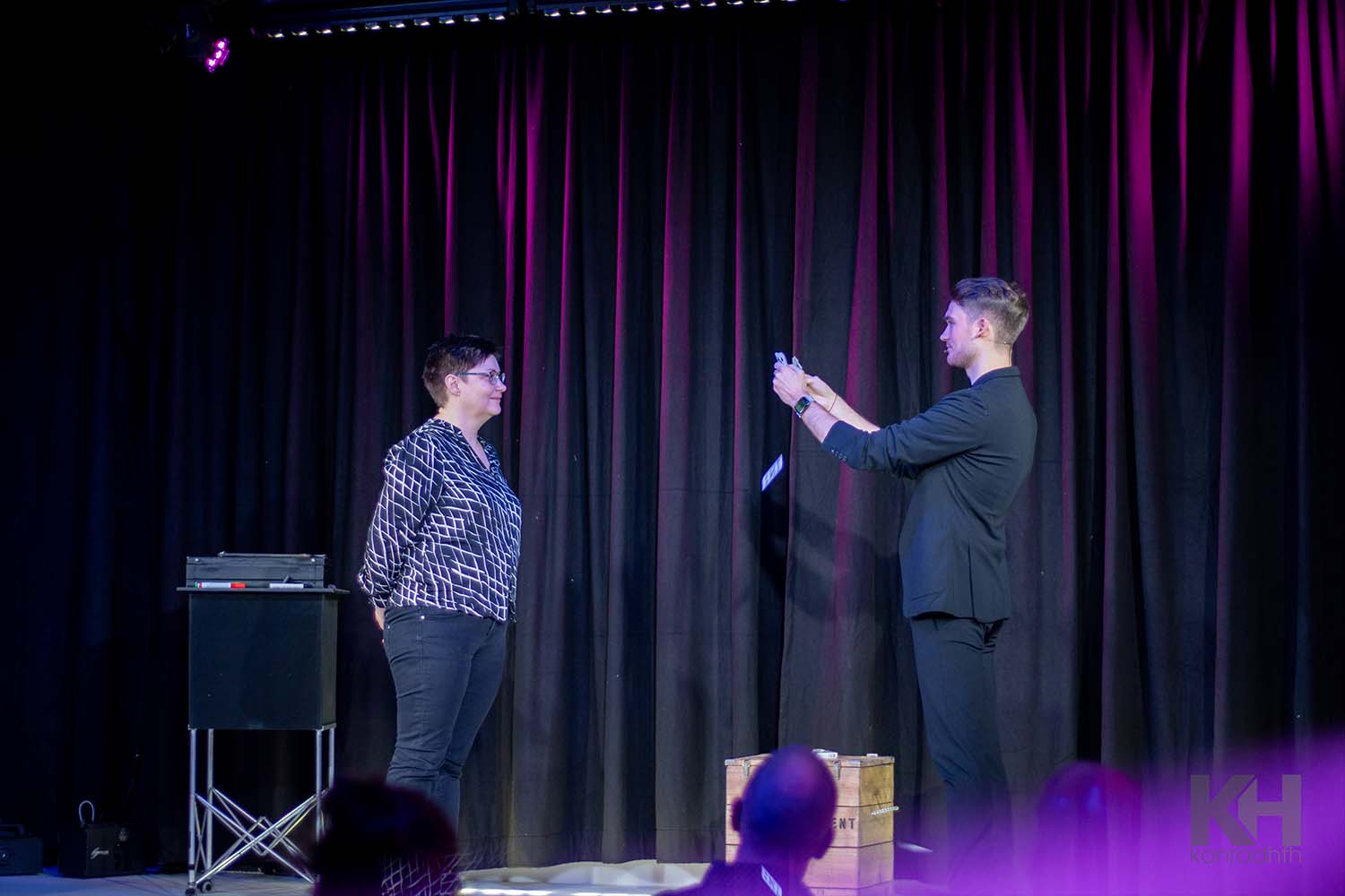 Zuschauerin steht Vincent Frommer gegenüber, während er Karten fallen lässt