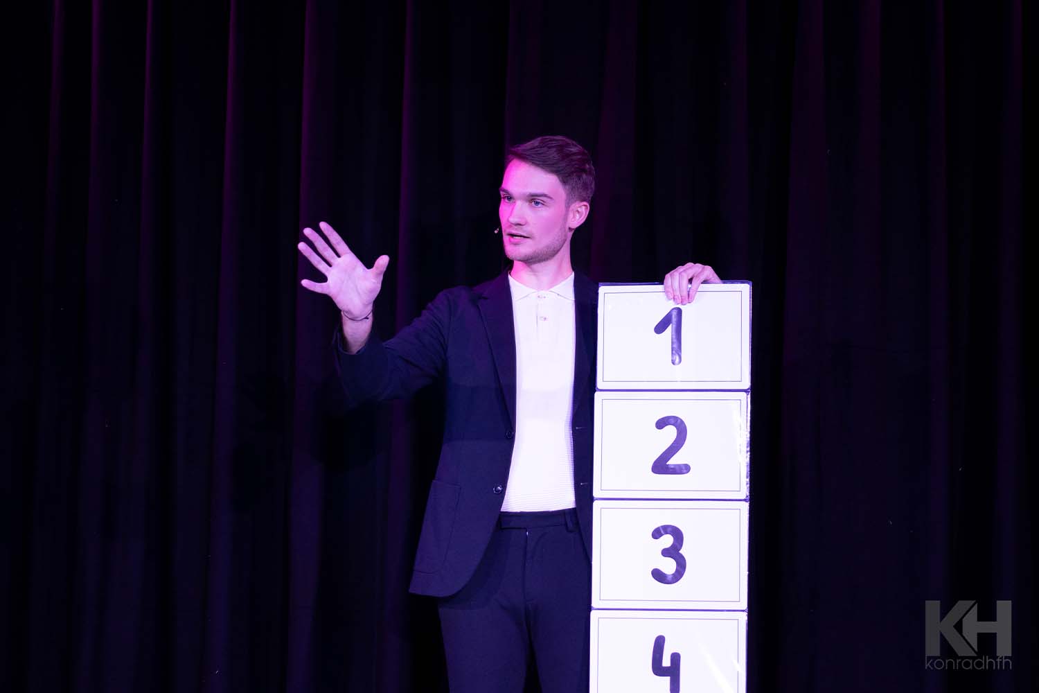 Vincent Frommer hält eine Tafel mit den Zahlen 1 bis 4 hoch