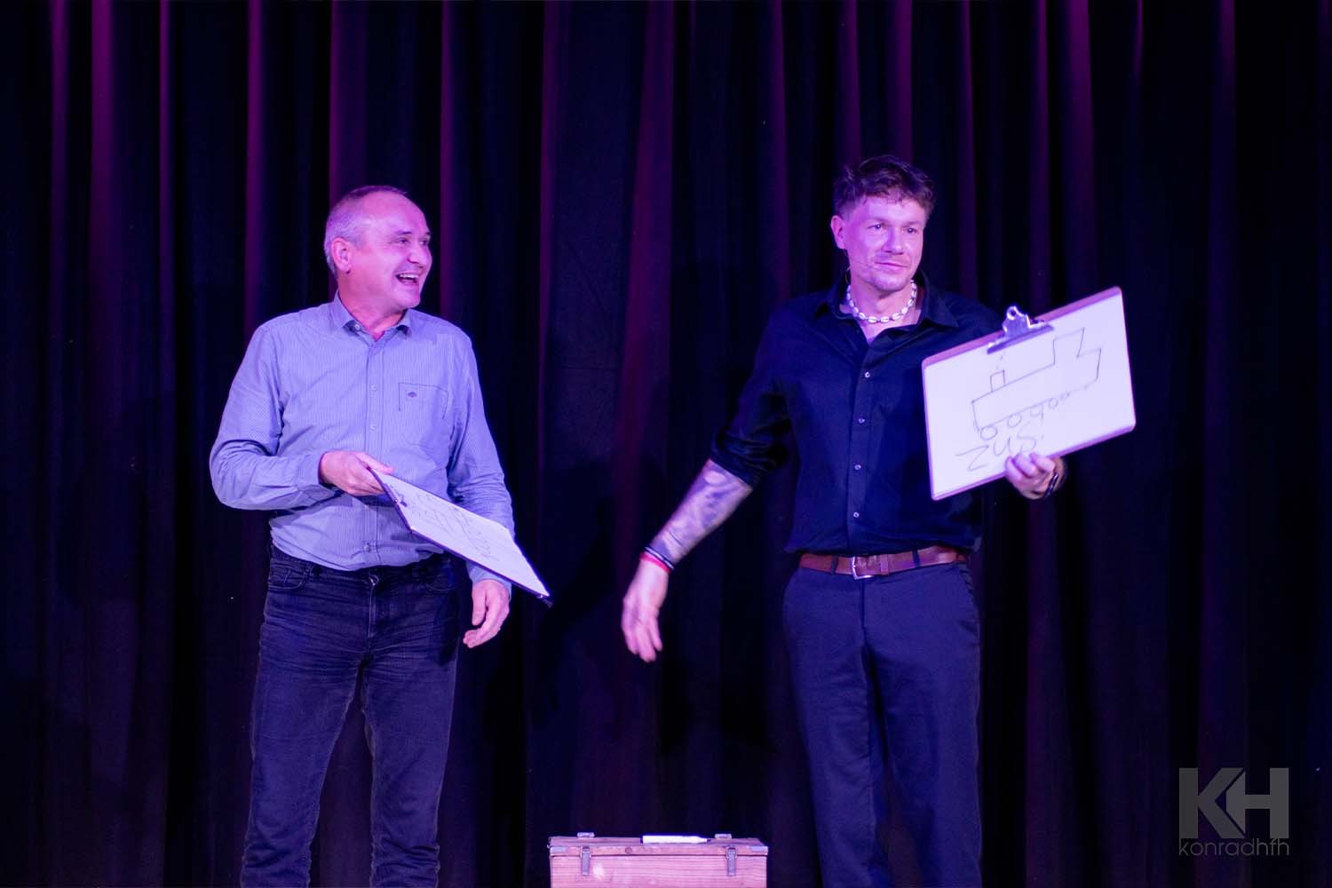 Lachender Zuschauer neben Thomas Majka, der gerade eine Vorhersage umdreht