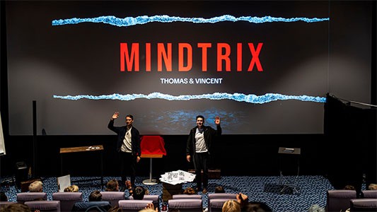 Thomas Majka und Vincent Frommer stehen auf der Bühne vor einer großen Leinwand mit dem Schriftzug Mindtrix bei der Premiere in Bautzen