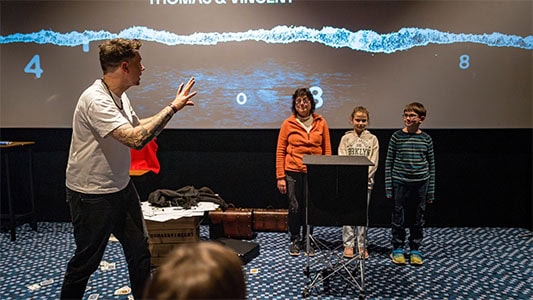 Thomas Majka steht mit drei Zuschauern auf der Bühne und zeigt einen Gedankenlese-Effekt während der Mindtrix-Show in Bautzen