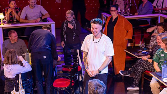 Thomas Majka steht mitten im Publikum während der Show im Carte Blanche Petit Theater Dresden