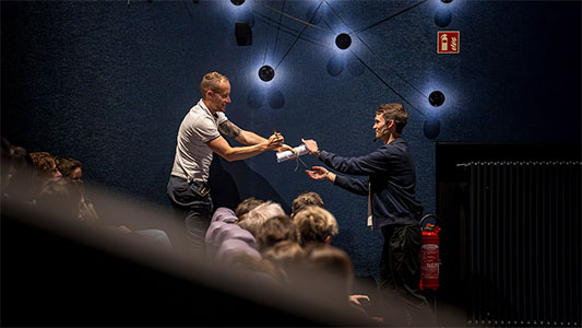 Ein Zuschauer übergibt Vincent Frommer eine Papierrolle während der Mindtrix-Show in Bautzen