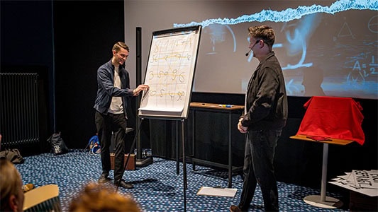 Vincent Frommer schreibt Zahlen auf ein Flipchart während der Mindtrix-Show in Bautzen