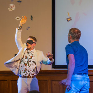 Zauberer Thomas Majka mit verbundenen Augen während Kartenexperiment mit Zuschauer