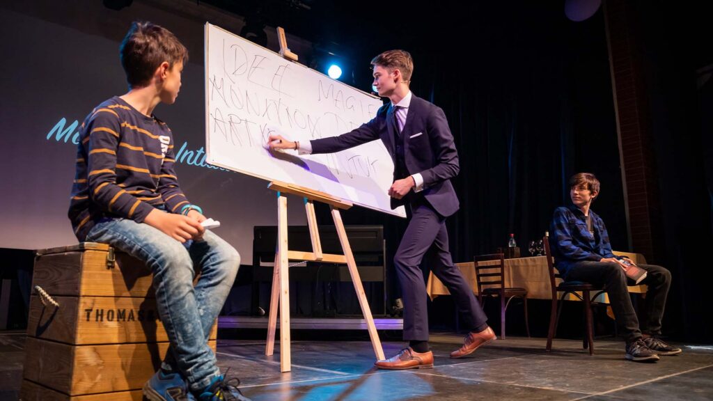 Vincent Frommer auf der Bühne bei einer Mentalmagie Show mit Zuschauer und Flipchart