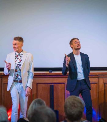 Thomas Majka und Vincent Frommer stehen auf der Bühne und sprechen mit dem Publikum.