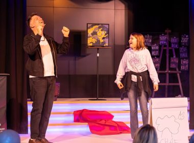 Zauberer Thomas Majka mit lachender Zuschauerin auf der Bühne