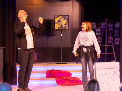 Zauberer Thomas Majka mit lachender Zuschauerin auf der Bühne